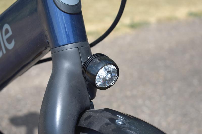A close-up of the Gocycle's front light, mounted on the stem just above the front wheel