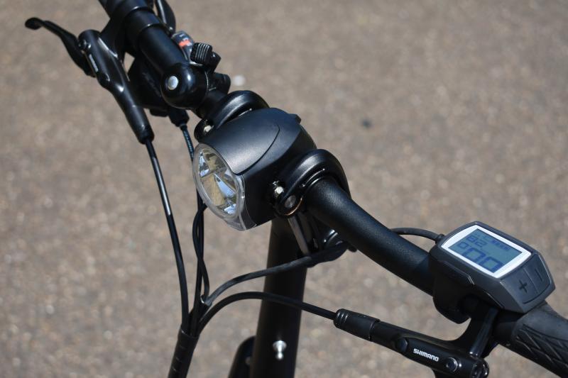 A close-up of the Tern's handlebar showing the handlebar-mounted front light and power meter