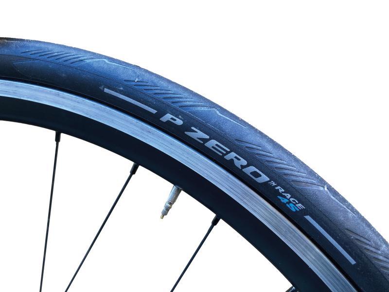 A close-up of the Pirelli P Zero Race 4S tyre showing the logo, on a bike wheel
