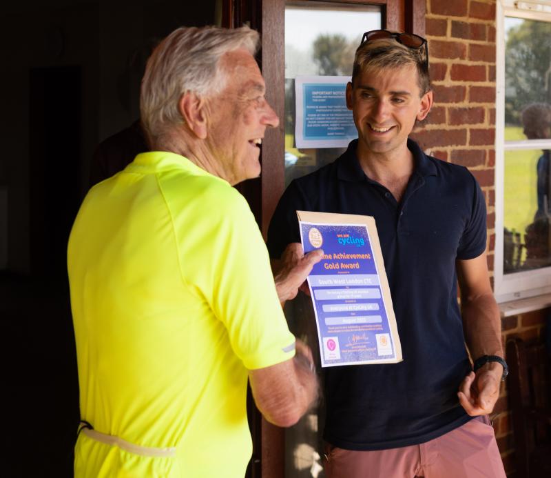 A man is presented with a certificate by another man