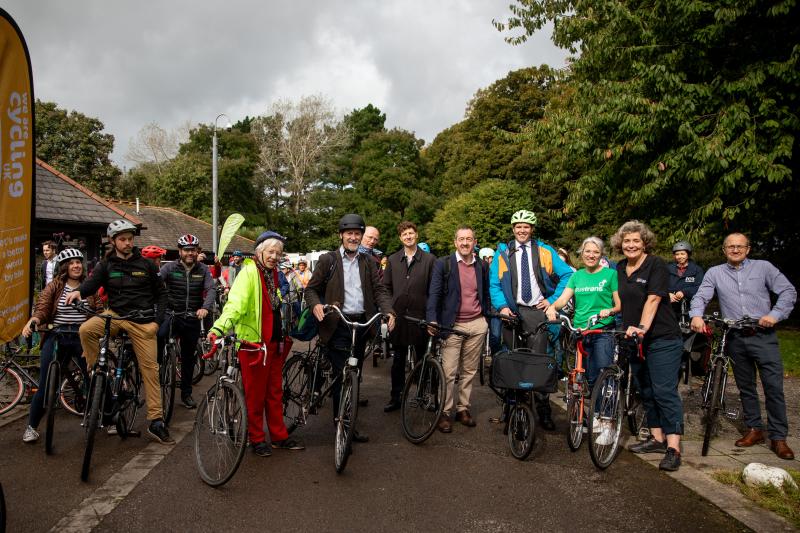 A group of people are all standing with their bikes getting ready to set off