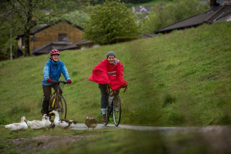 Two people cycling in the rain