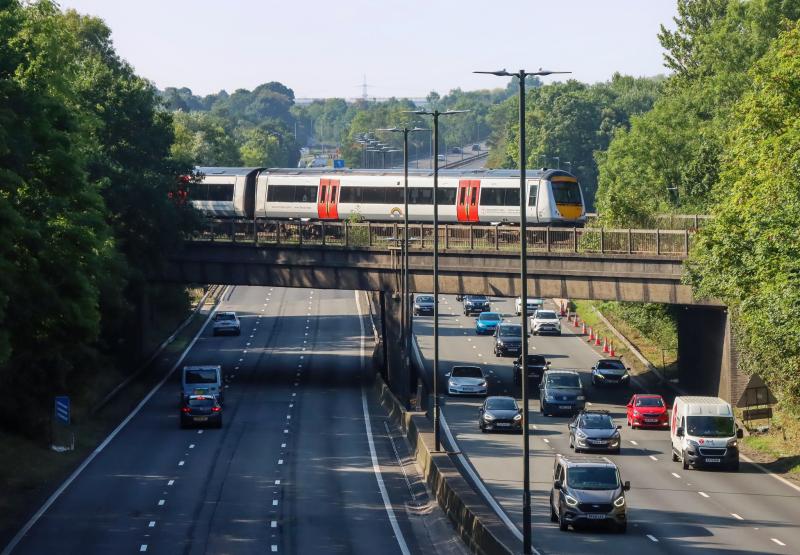 Train passing over a rail bridge above a motorway at Newport