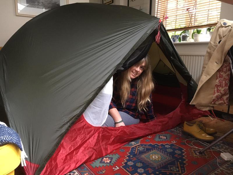 A woman is camping in her living room