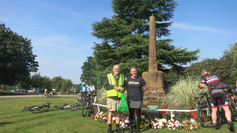 John and Christina Bengston standing in front of the monument commemorating Meriden as the traditional centre of England