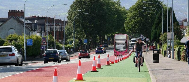 Woman cycling along a temporary cycle lane marked with cones