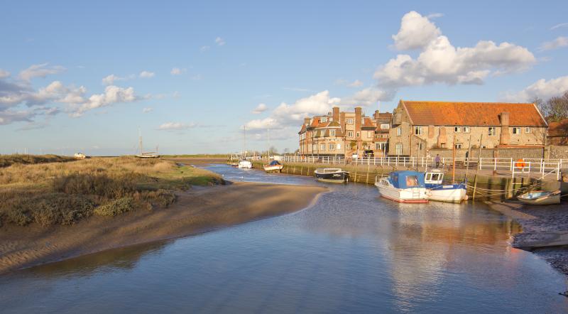 Estuary with boats and stone houses in golden evening light