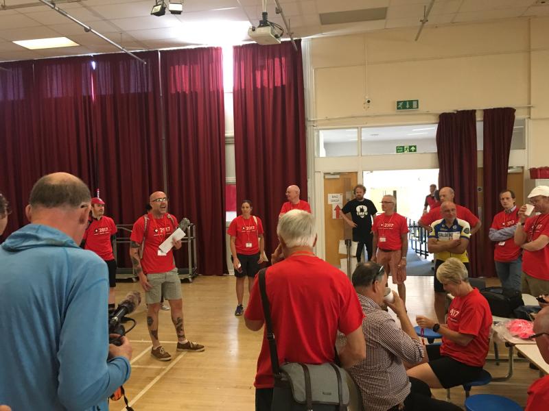 A man presents to a group of people in a village hall