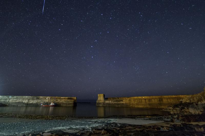 Dark starry sky above a harbour