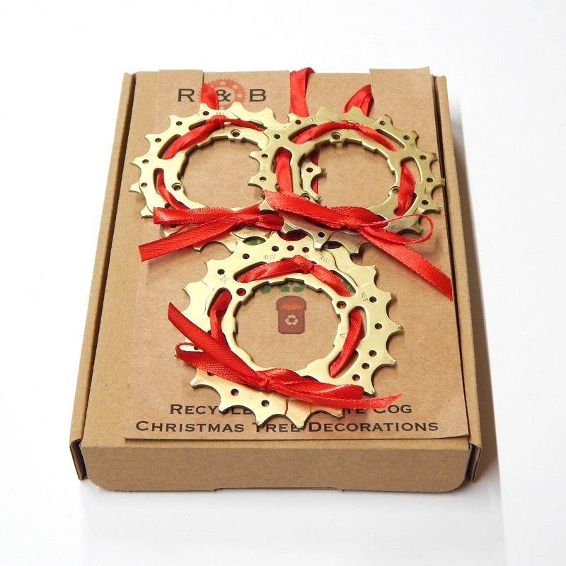 Three Christmas decorations made from an old cassette cog with red ribbon tied through it