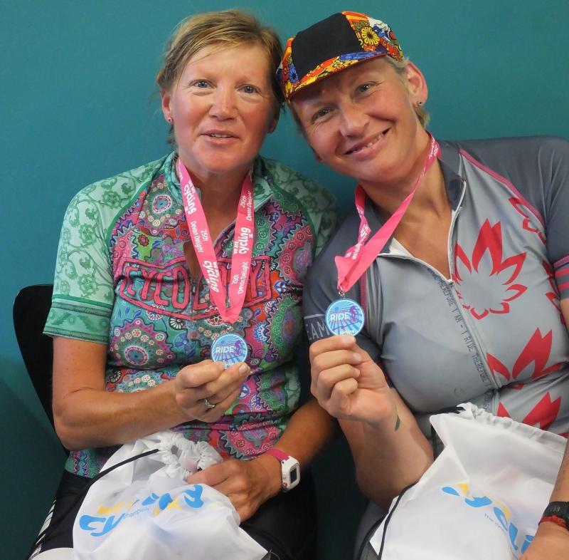 Two cyclists with medals and goodie bags. Photo by Graham Brodie