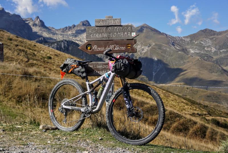 A full-suspension mountain bike poses in a mountain landscape