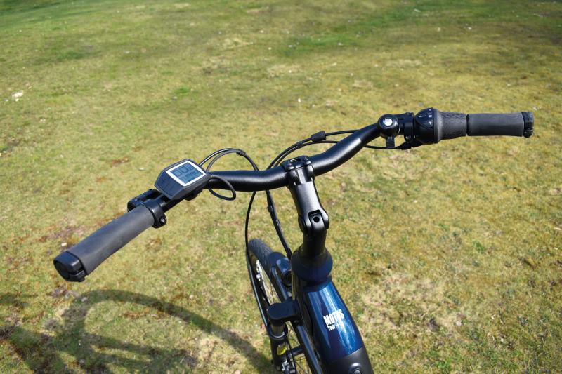 An e-bike's handlebars with a Speedometer on the left hand side