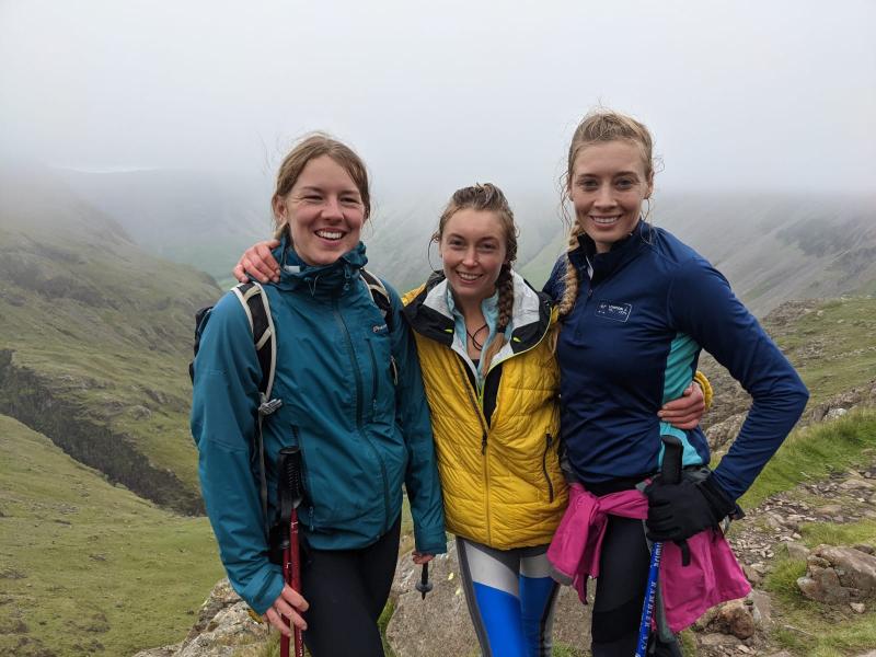 Cass, Emily and Saoirse on top of one of the peaks with a misty landscape behind them