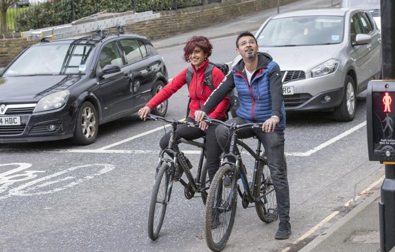 Two cyclists stopped at traffic lights