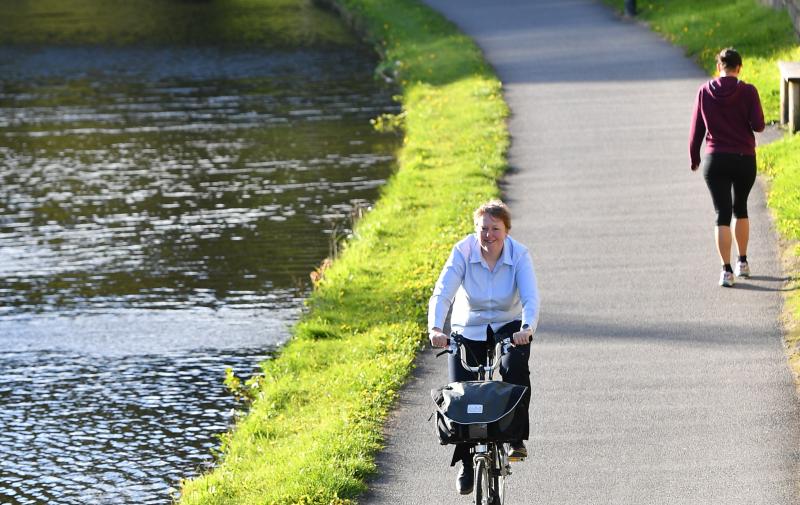 Woman cycling along a canal
