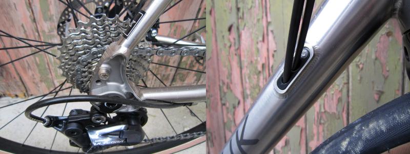 Left: Neatly CNC-machined rear dropouts with rack and mudguard mounts. Right:Cables and rear brake hose run through the frame via reinforced entry ports either side of the down tube