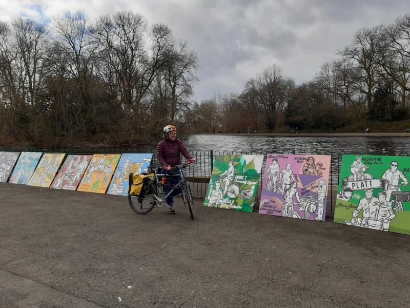 woman with large boards with pieces of mural painted on each