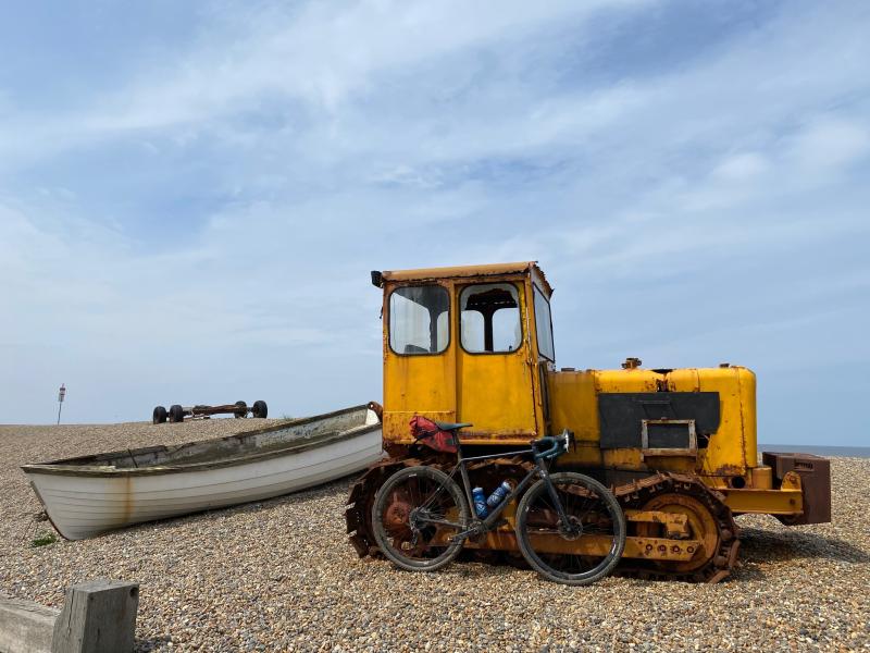 Yellow caterpillar tractor on a pebbled beach