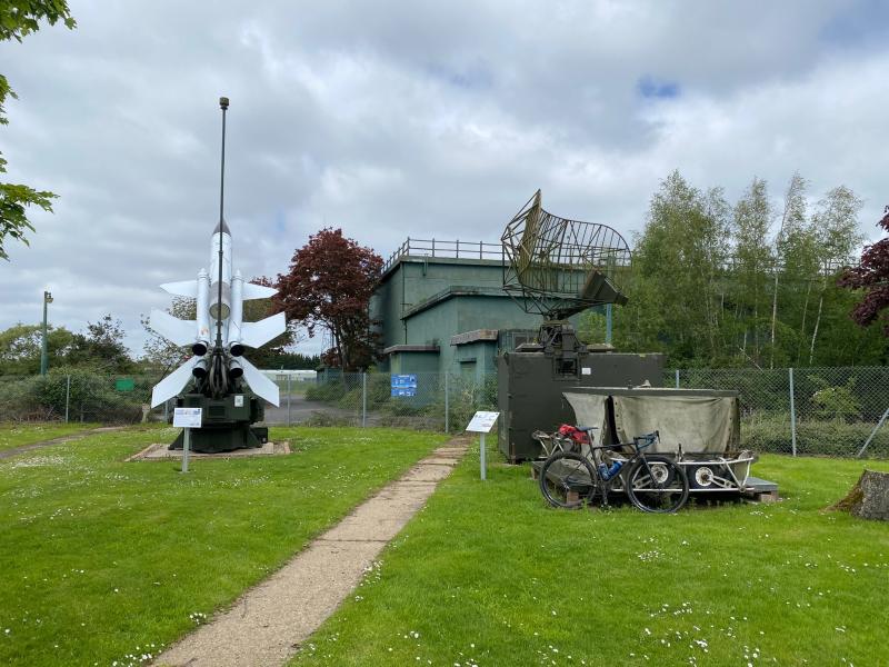 Model aeroplane in front of dark green museum building