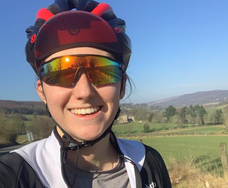 Close up of woman smiling wearing reflective shades and cycle helmet