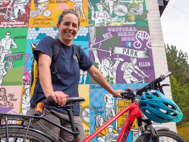 close up of woman with bike in front of mural