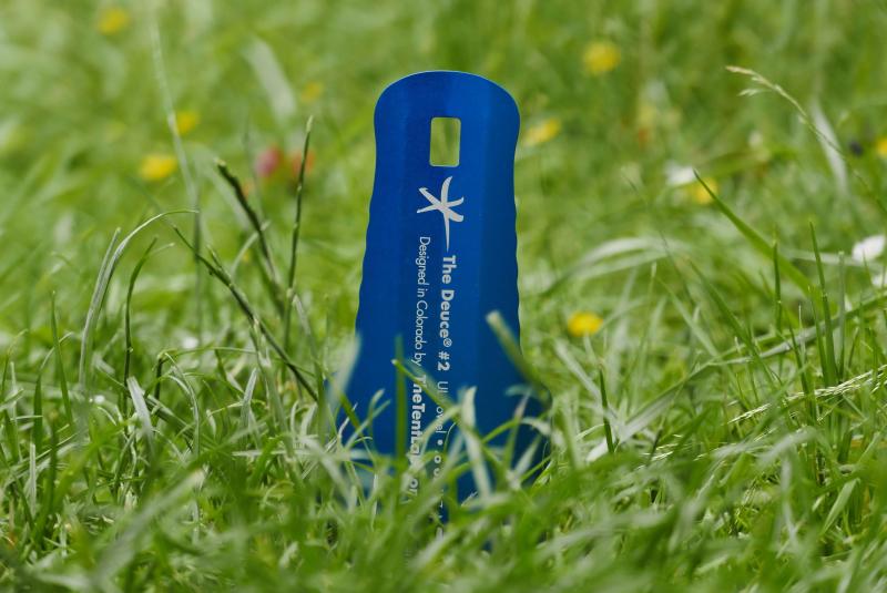 A camping trowel stuck in the ground