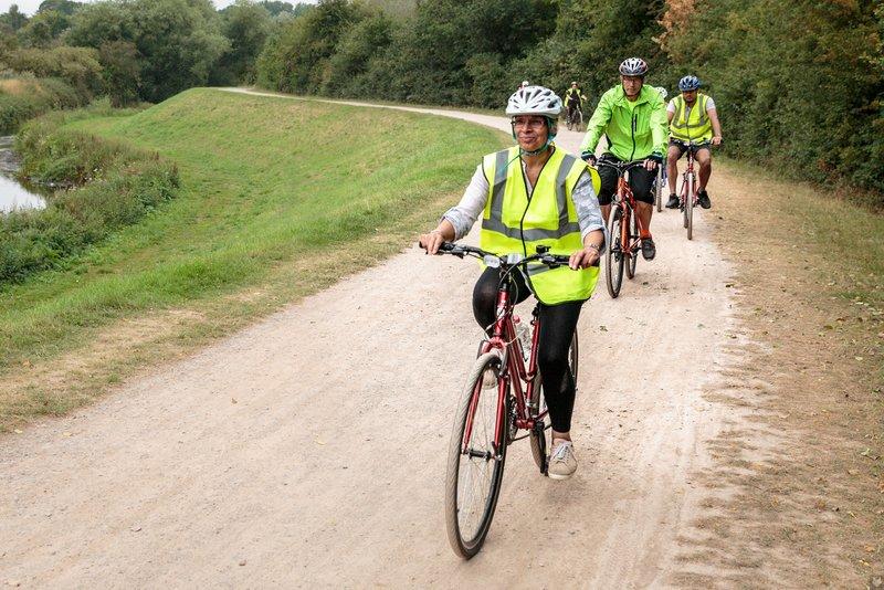 Two cyclists in yellow hi-vis riding an off-road path