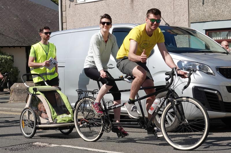 Three people riding a tandem with child trailer at the Lon Las Mon rally