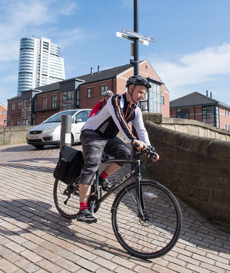 A commuter riding over a bridge in Leeds