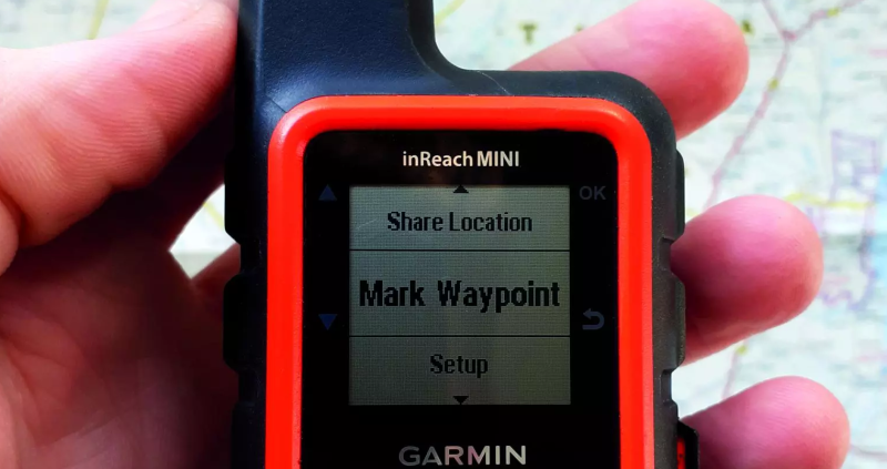 close up shot of person holding Garmin InReach mini device