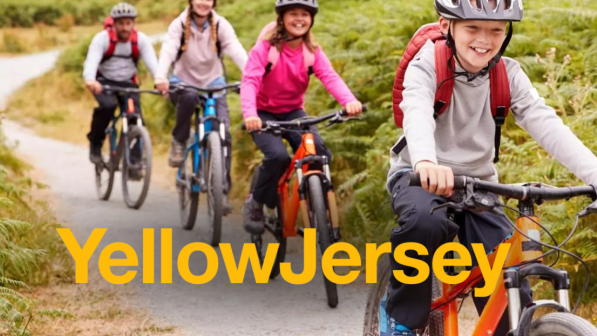 Children cycling in a line outside on a grey path with the yellow jersey logo overlay