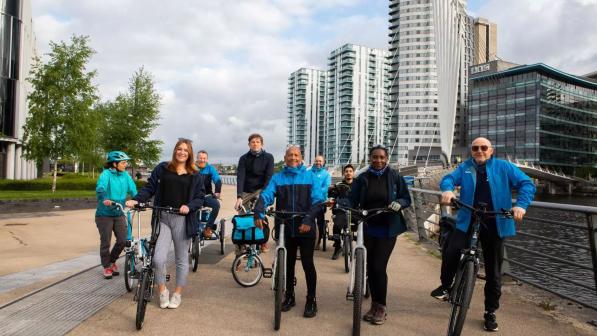 Staff members outside at a launch event standing next to their bikes