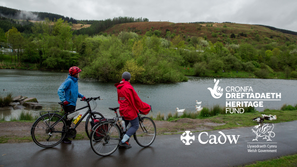 Two women with bikes looking out over a lake