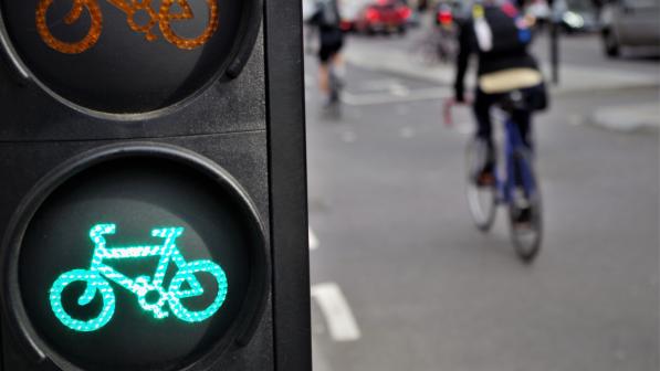 Cyclist going through green cycle lane light 