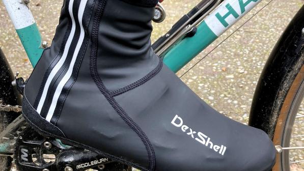 A black overshoe with reflective piping and DexShell logo in use