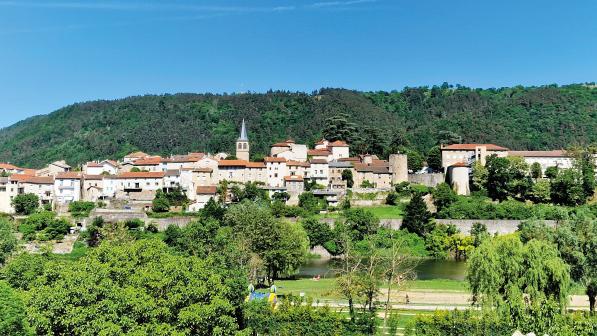 A town with church spire set amid a pine forest on a hill