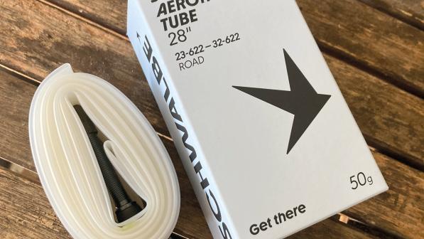 The Schwalbe Aerothan innertube box next to the tube itself, which is white, on a wooden table