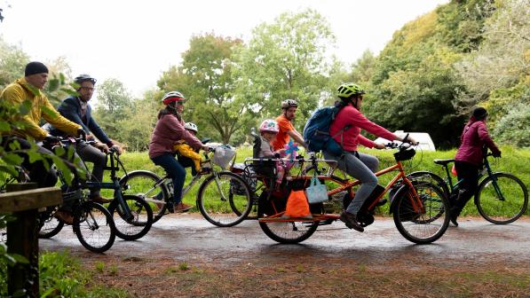 A group of people cycling in everyday clothes on different types of cycles