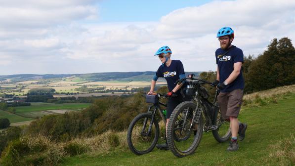 Sam Jones (right, CUK) and Hannah Dobson (Singletrack) walking their bikes towards the Crown on Wye September 30, 2018. The riders were undertaking a recce of Cycling UK's proposed "riders route" of the North Downs Way as part of the 40th anniversary celebrations of the national trail.