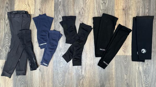 A selection of arm and knee warmers from Decathlon, Castelli, Sportful, Rapha and Stolen Goat are arranged on a floor