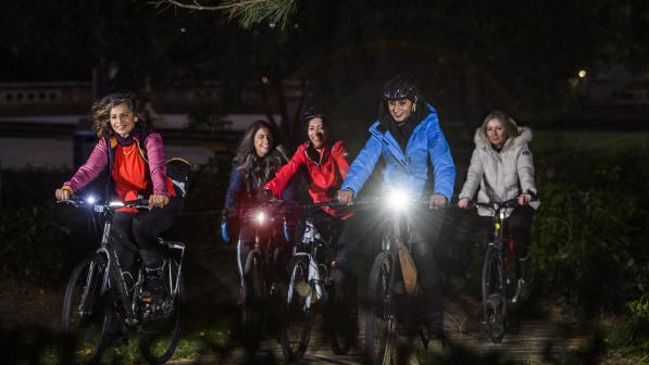 A group of women cycling in the dark