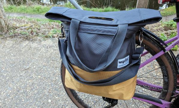 A grey and gold pannier is attached to a rear rack