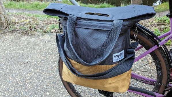 A grey and gold pannier is attached to a rear rack