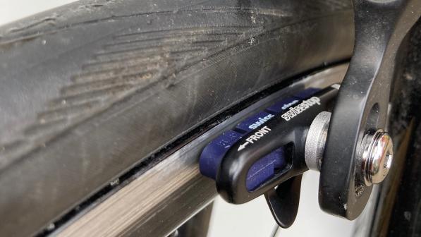 A close-up of a brake pad and shoe in Shimano sidepull callipers