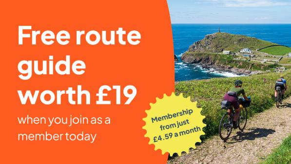 Text reads 'free route guide worth £19 when you join as a member today'. The image showed two people riding down a coastal gravel path