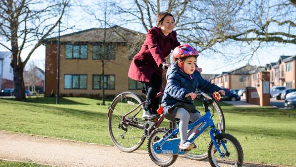 Mother and daughter cycling together on a cycle path