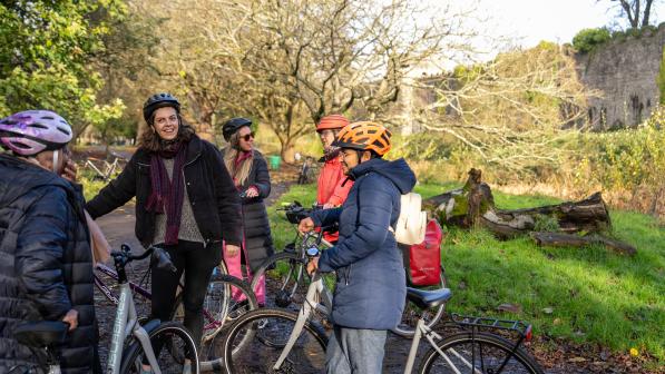 A group of women with bikes chatting in a park