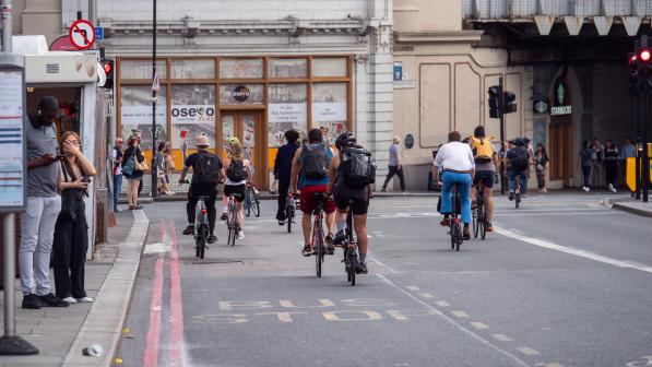 Cyclists coming off London Bridge approaching a red light