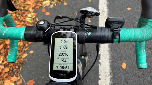 A Garmin bike computer attached to the stem of a road bike with turquoise bar tape
